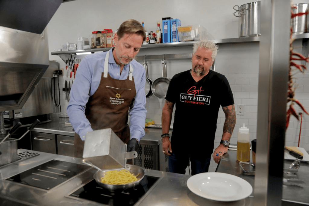 Guy Fieri and Federico Perandin cooking together in the Il Pastaficio kitchen