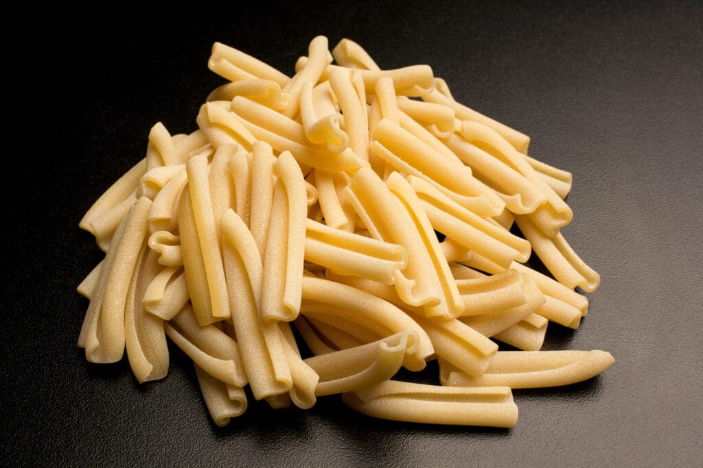 Pile of raw casarecce di grani antichi on dark slate