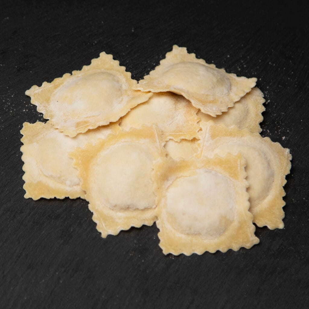 Fresh square ravioli Emilia on dark slate
